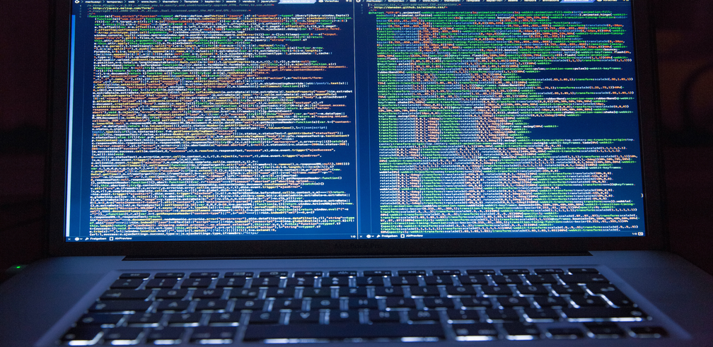 Image of a laptop with lines of code on the screen.