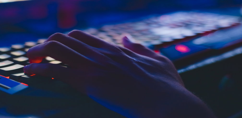 Image of a hand typing on a computer keyboard.